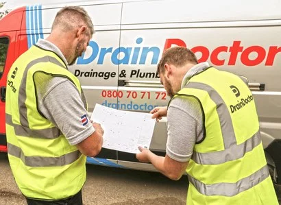 Two Drain Doctor engineers looking at drain map