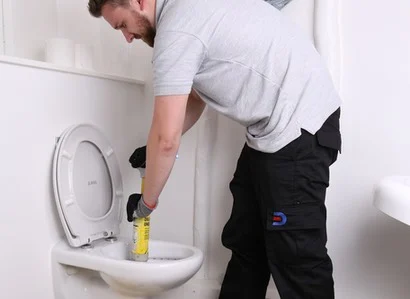 Engineer unblocking toilet