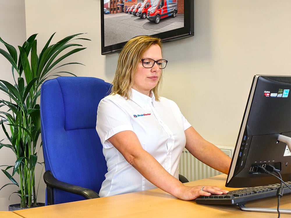Drain Doctor team member working on the computer