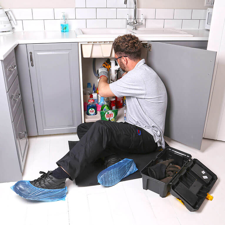 Drain Doctor engineer working under sink