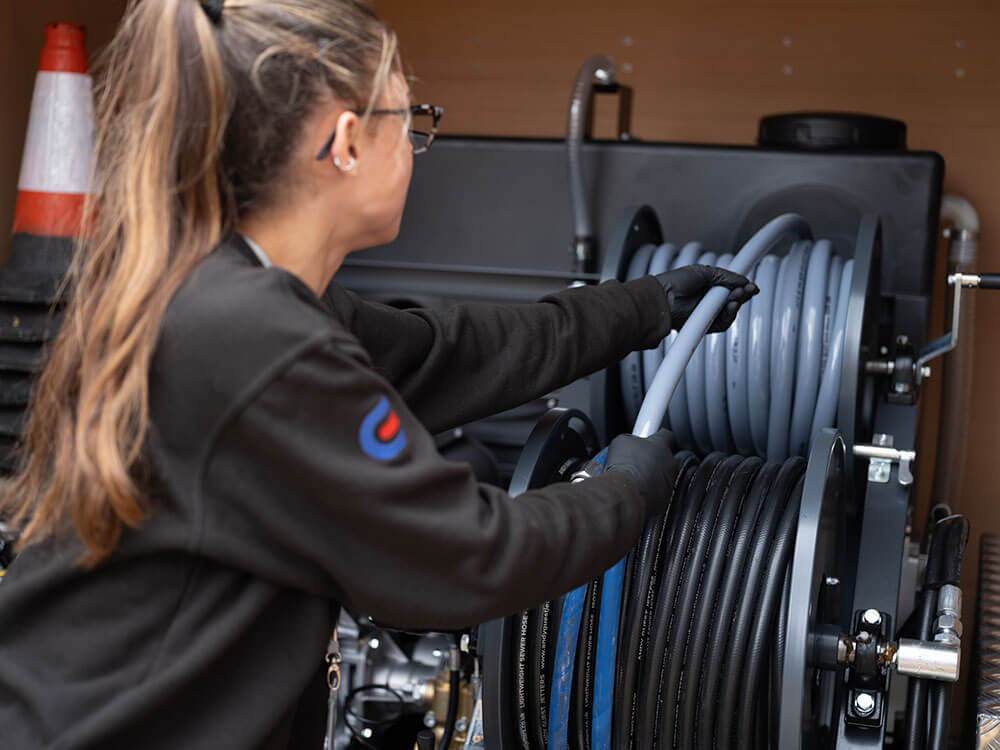 Drain Doctor engineer pulling pipes from van