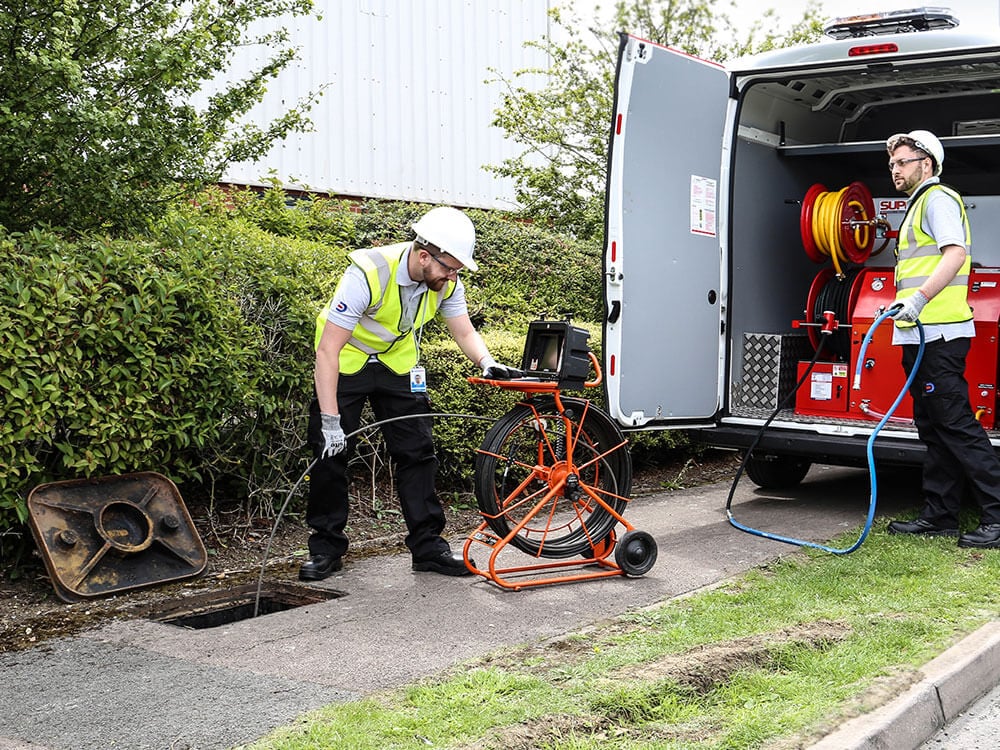 Two Drain Doctor engineers working from van