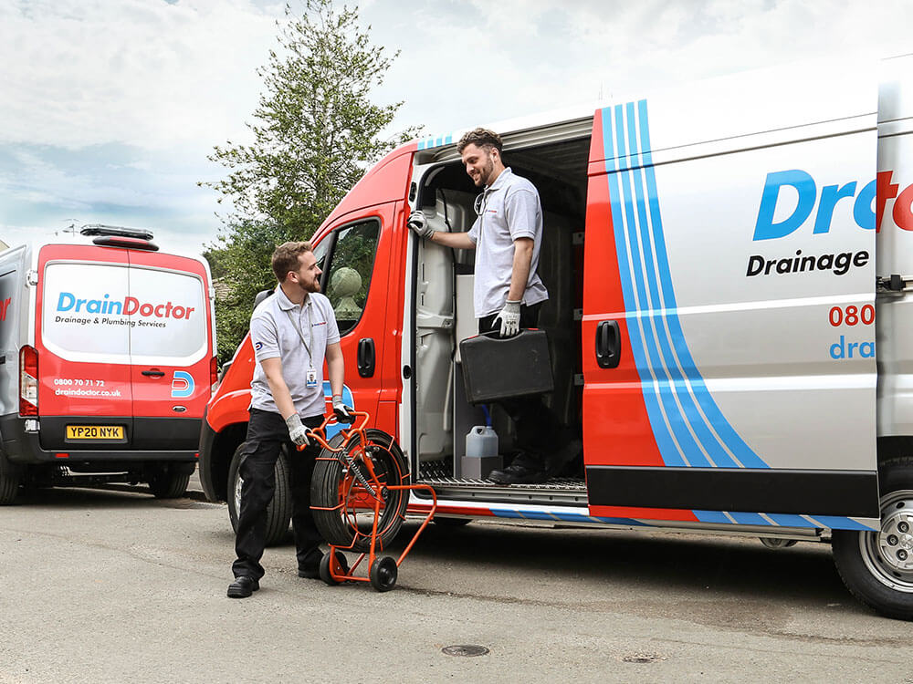 two engineers exiting the drain doctor van