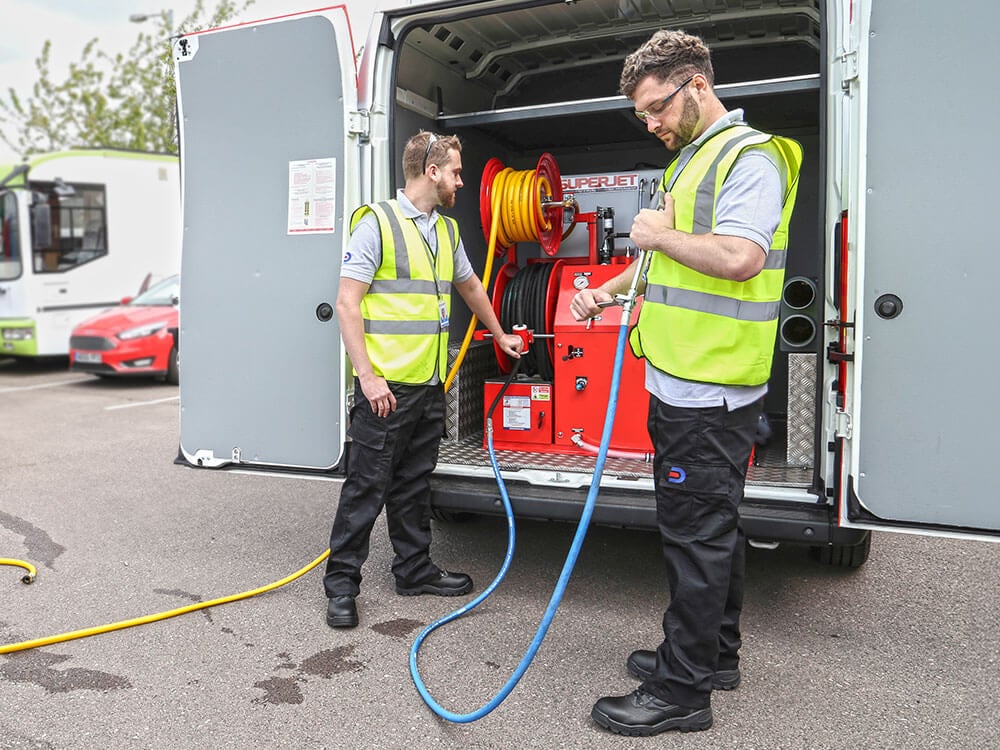 Two Drain Doctor engineers working from van