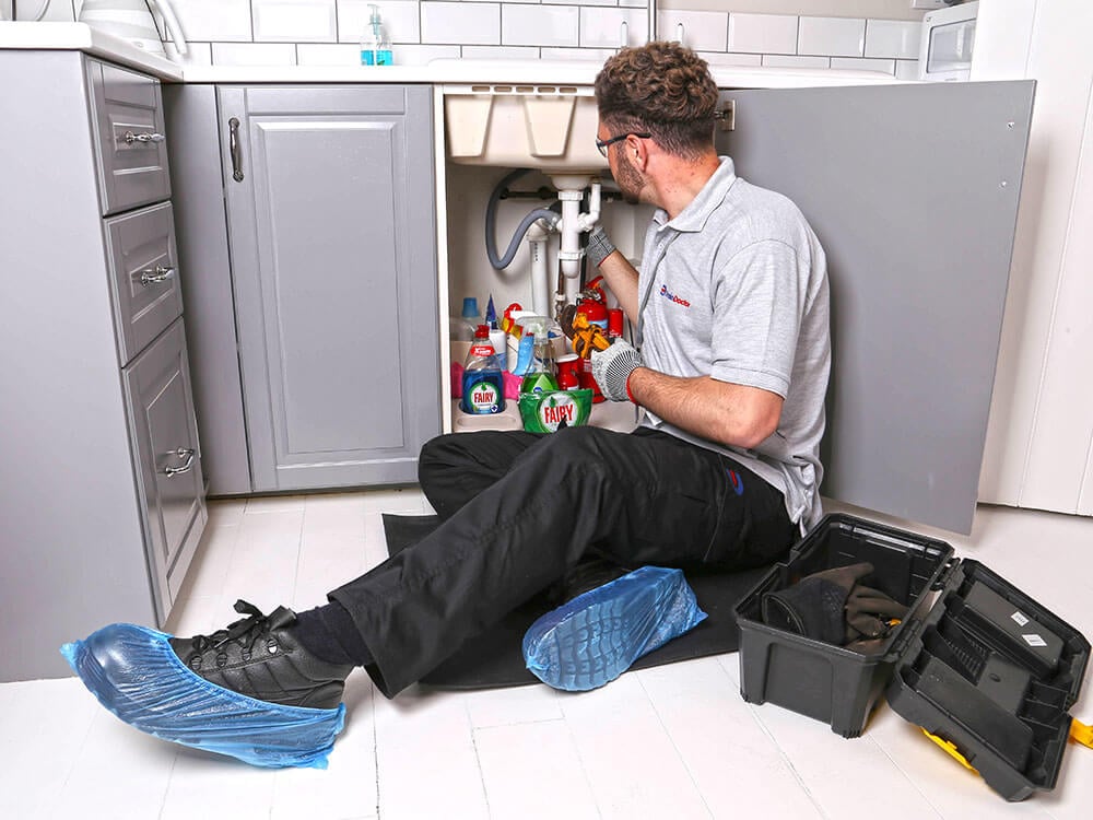 Drain Doctor engineer working under a sink