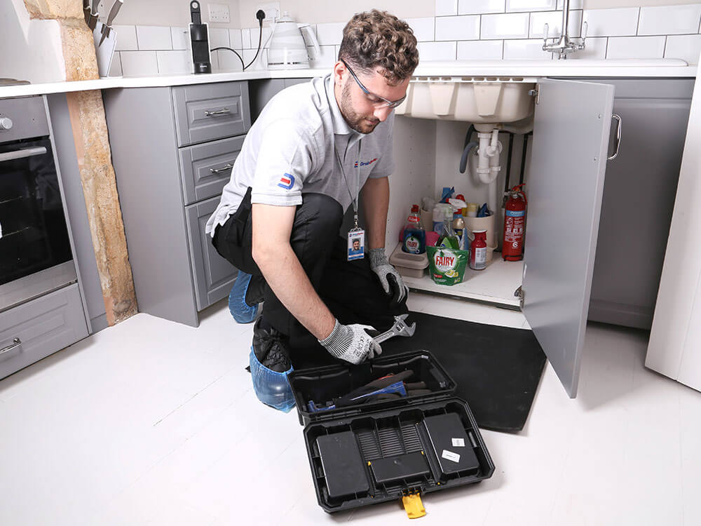 Drain Doctor engineer working under a sink